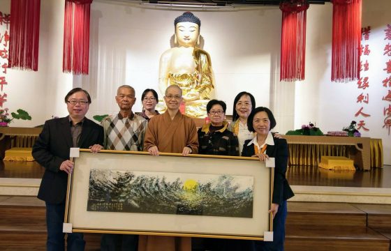 曹文娟(右) 偕同家人和水墨畫老師袁之靜將自己的作品捐給佛光山的惠中寺。